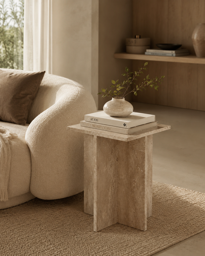CANOVA natural beige travertine side table by DEKATO LIVING styled beside a bed in a soft sunlit bedroom