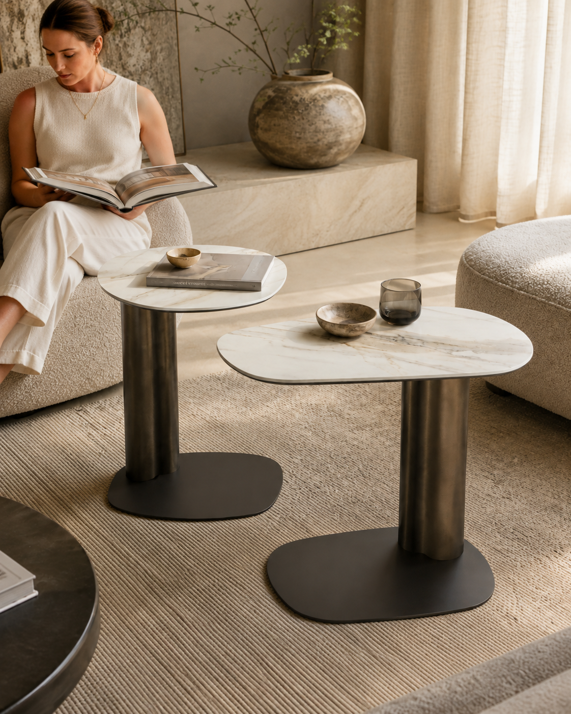 KAVO ceramic and bronze side tables by DEKATO LIVING with a woman reading beside the sofa