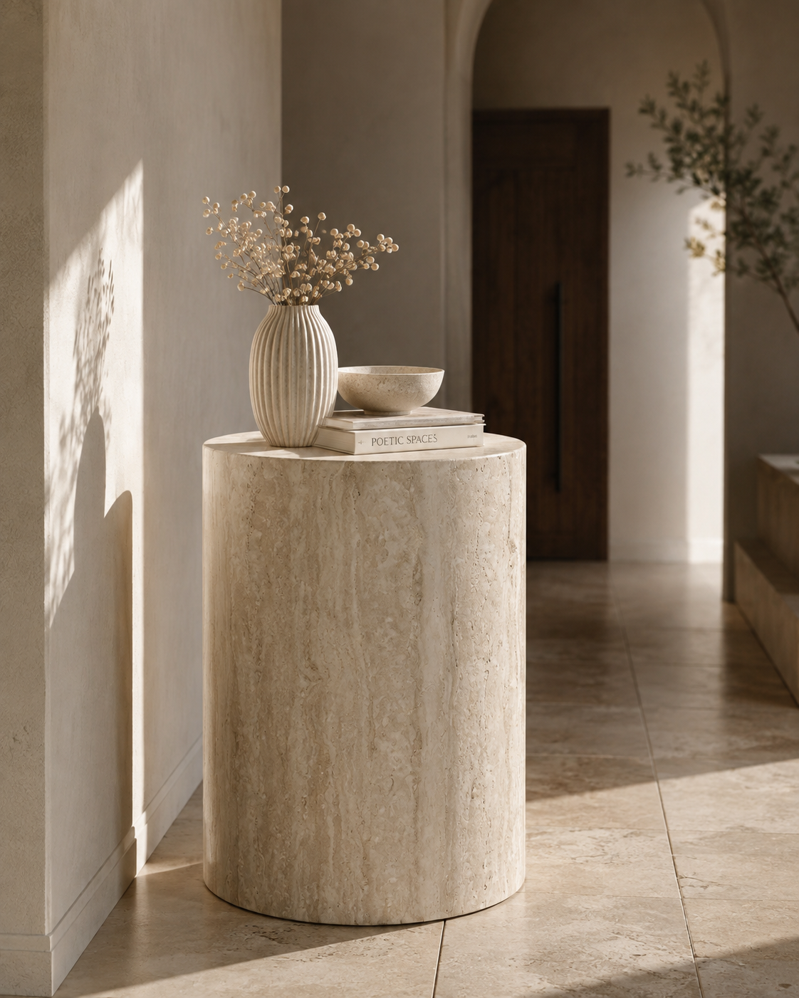 ORLO natural travertine cylindrical plinth by DEKATO LIVING styled in a softly lit contemporary hallway