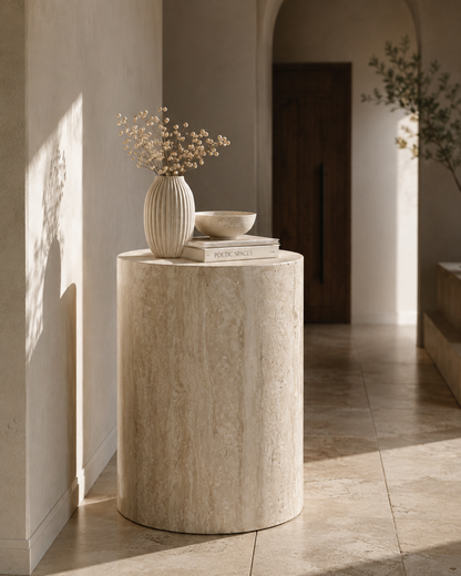 ORLO natural travertine cylindrical plinth by DEKATO LIVING styled in a softly lit contemporary hallway