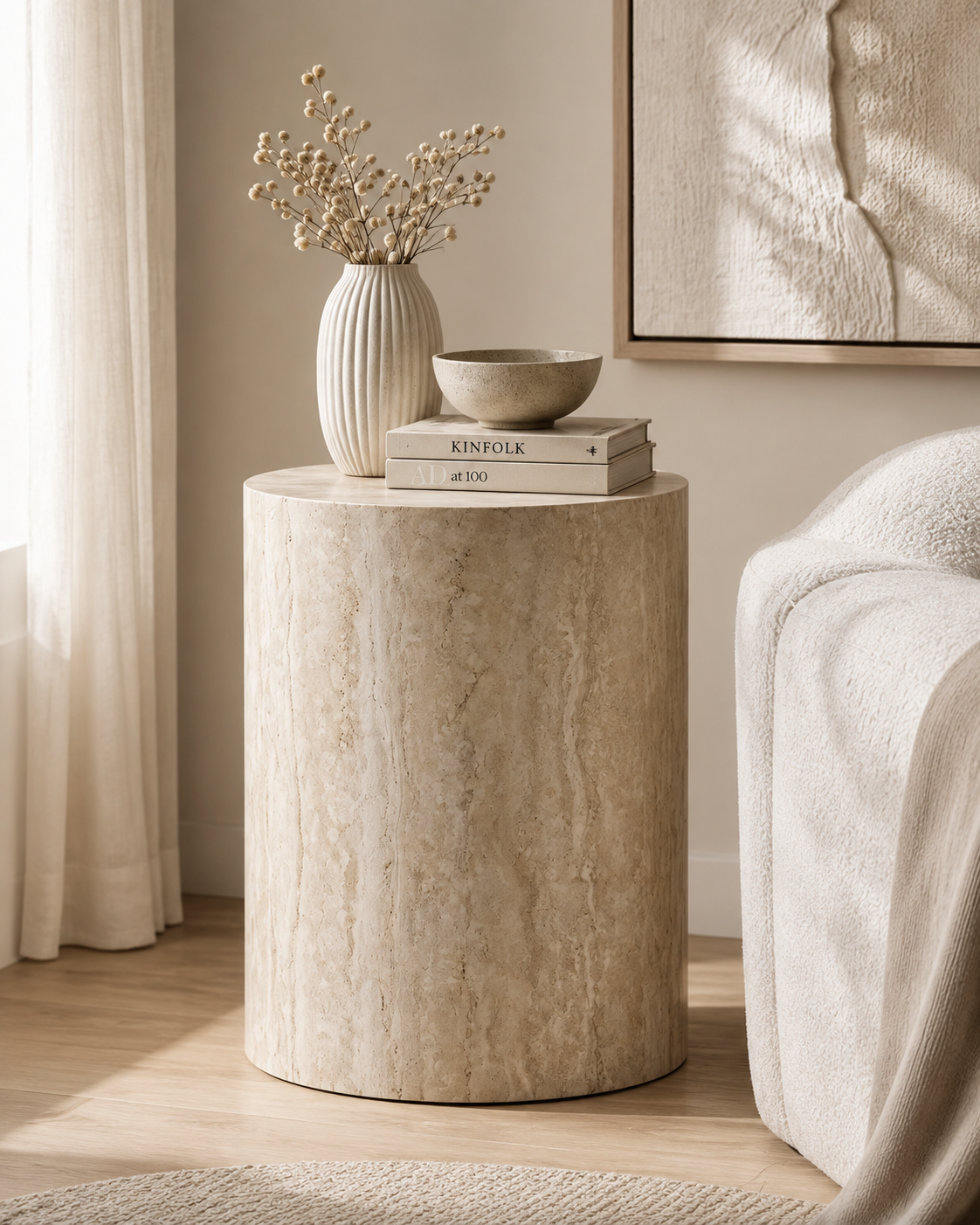 ORLO beige travertine pedestal table by DEKATO LIVING styled with books and ceramics in a calm living room