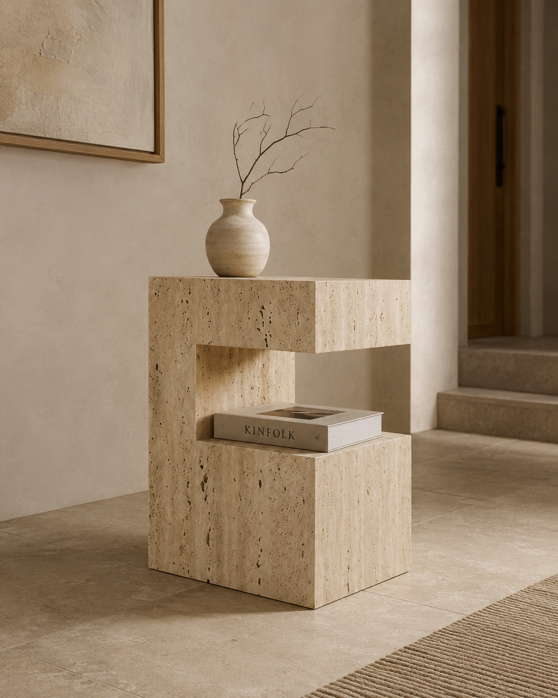 PIETRA sculptural travertine side table by DEKATO LIVING beside a man seated with coffee in a warm contemporary living room
