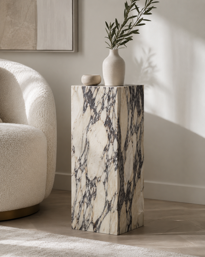 VIOLA Calacatta Viola marble pedestal by DEKATO LIVING styled beside a cream lounge chair in a warm neutral interior