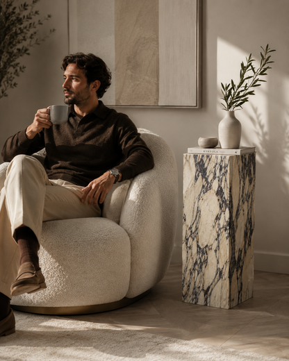 VIOLA Calacatta Viola marble pedestal by DEKATO LIVING beside a man relaxing with coffee in a contemporary lounge
