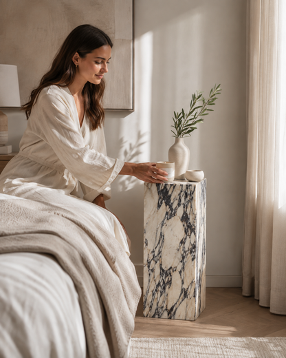 VIOLA rectangular Calacatta Viola marble bedside pedestal by DEKATO LIVING with a woman in a calm neutral bedroom
